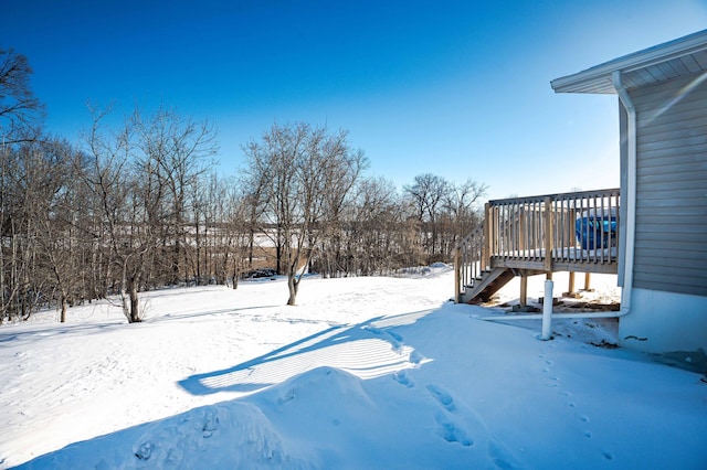 yard layered in snow with a wooden deck and stairs