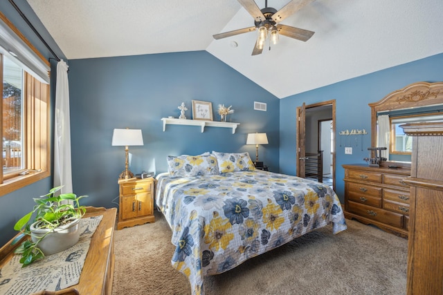 bedroom featuring a ceiling fan, light colored carpet, vaulted ceiling, and visible vents