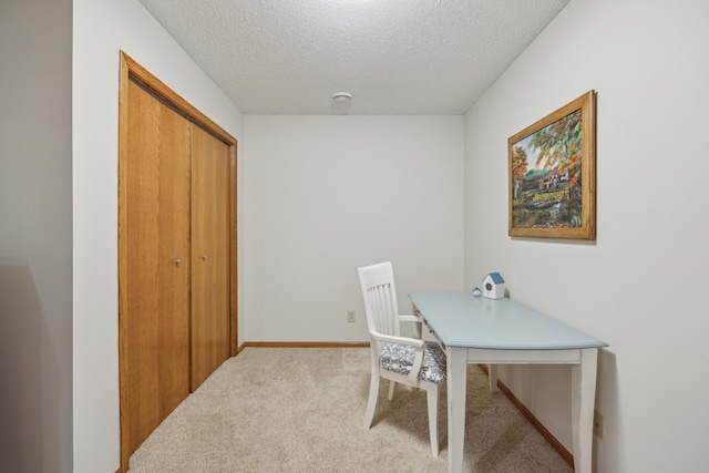 home office featuring light carpet, a textured ceiling, and baseboards