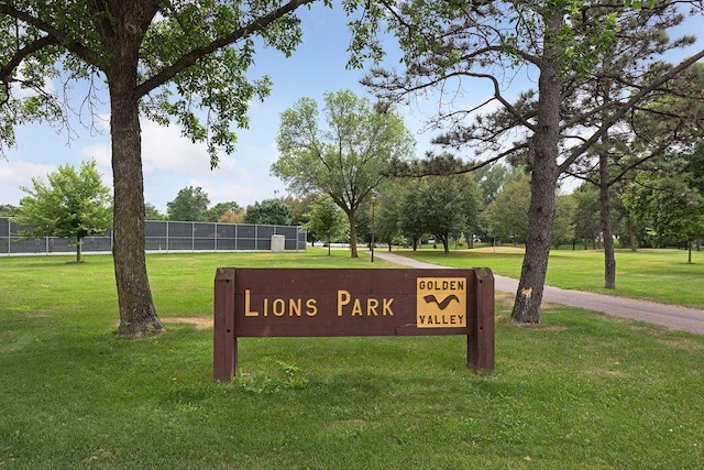 community sign with a lawn and fence