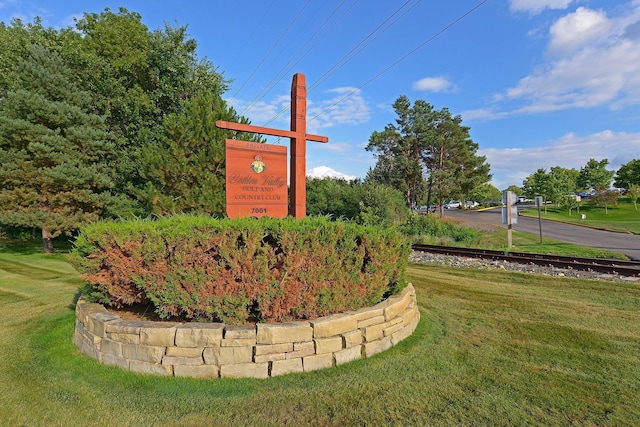 community / neighborhood sign featuring a yard