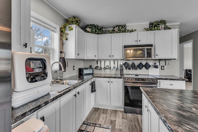27939 Forest Blvd, Wyoming, MN 55092 - kitchen featuring appliances with stainless steel finishes, white cabinets, dark stone countertops, and light wood-type flooring