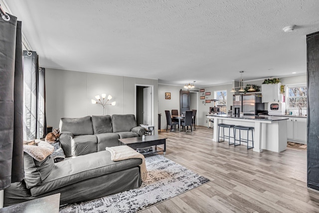 27939 Forest Blvd, Wyoming, MN 55092 - living area with light wood-style flooring, a textured ceiling, and a chandelier