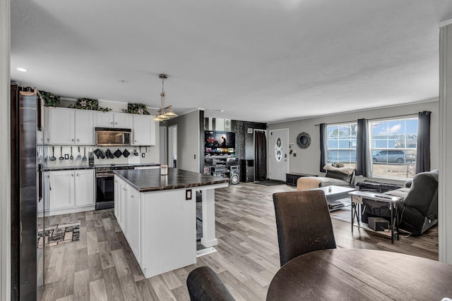 27939 Forest Blvd, Wyoming, MN 55092 - kitchen with stainless steel appliances, open floor plan, dark countertops, and a kitchen island