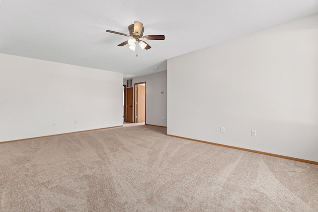 unfurnished room featuring light carpet, a ceiling fan, and baseboards