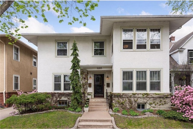 view of front of property featuring a front yard and stucco siding