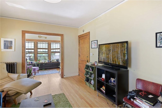 sitting room with light wood-style floors and crown molding