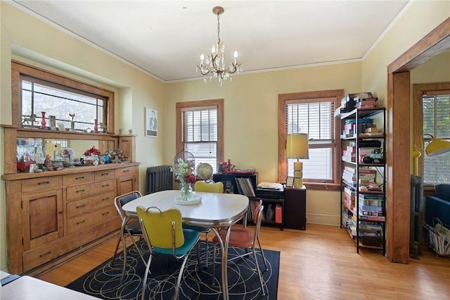 dining space with light wood-type flooring, ornamental molding, and a wealth of natural light