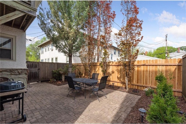 view of patio featuring outdoor dining area, a fenced backyard, and grilling area