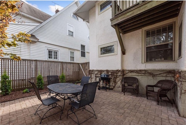 view of patio featuring outdoor dining area, fence, and grilling area