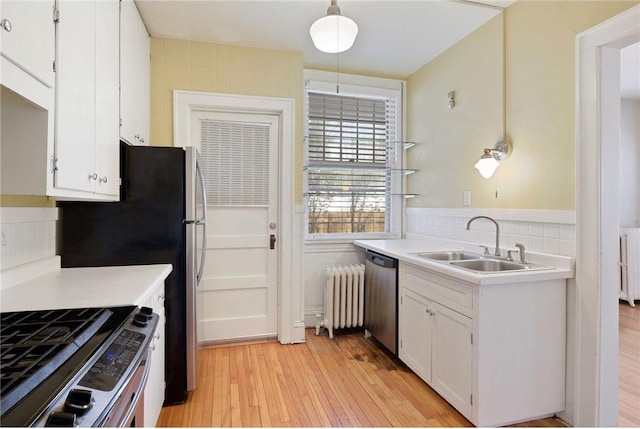 kitchen with white cabinets, light countertops, a sink, and decorative light fixtures