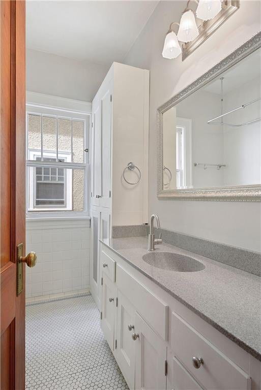 bathroom featuring tile patterned flooring, tile walls, and vanity