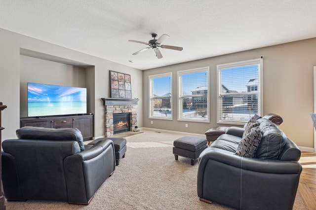 living area with a textured ceiling, a fireplace, and baseboards