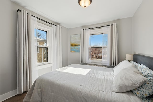 bedroom featuring baseboards and dark wood-style flooring