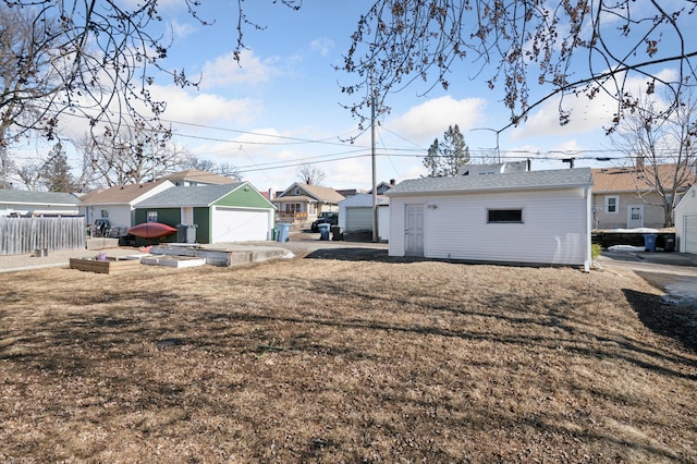 exterior space with an outbuilding, fence, a residential view, a vegetable garden, and a garage