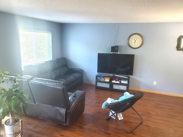 living room with a textured ceiling, dark wood finished floors, and baseboards