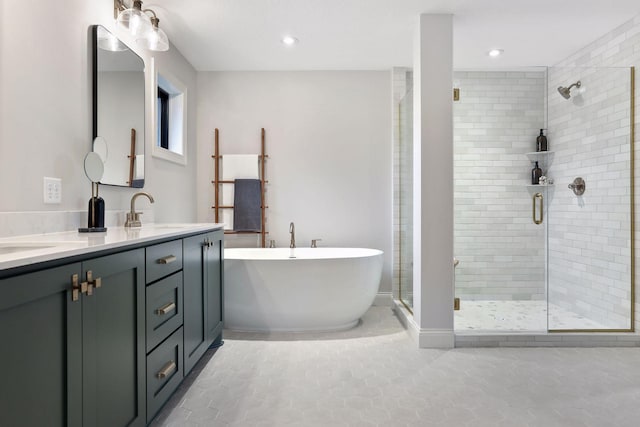 full bath featuring double vanity, a freestanding tub, a sink, and a shower stall