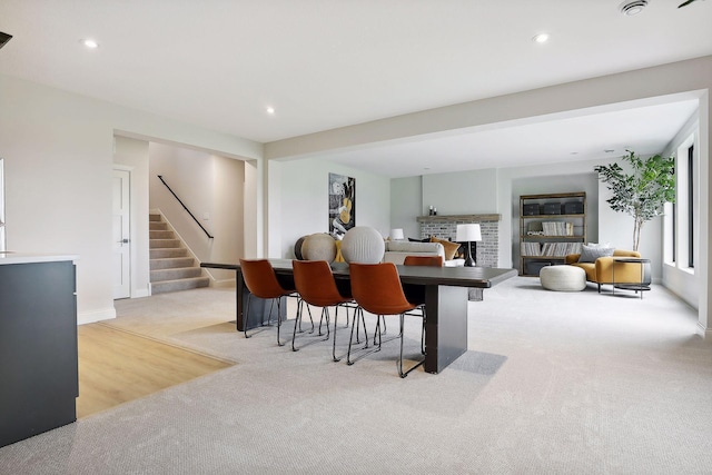 dining area with stairway, a fireplace, light colored carpet, and recessed lighting