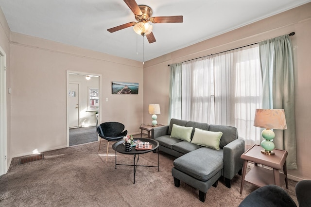 carpeted living area with ceiling fan and visible vents