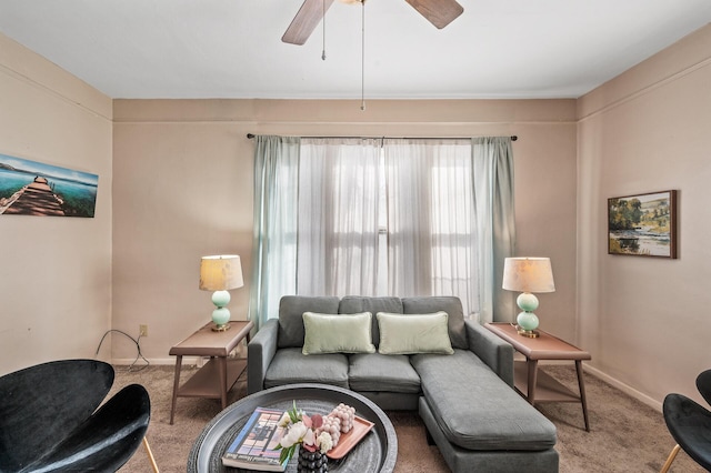 carpeted living room with ceiling fan and baseboards