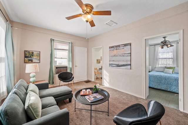 living area with ceiling fan and visible vents