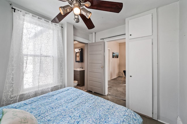 bedroom featuring a ceiling fan, multiple windows, and connected bathroom