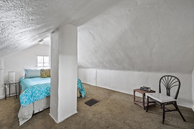 carpeted bedroom featuring a textured ceiling and vaulted ceiling