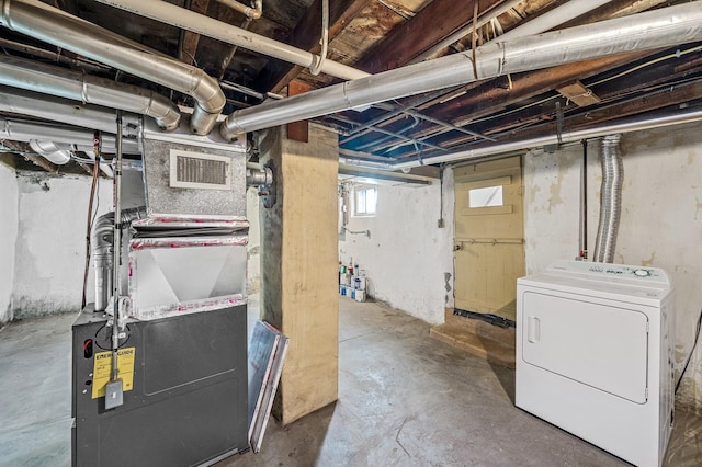 basement featuring heating unit, washer / dryer, and visible vents