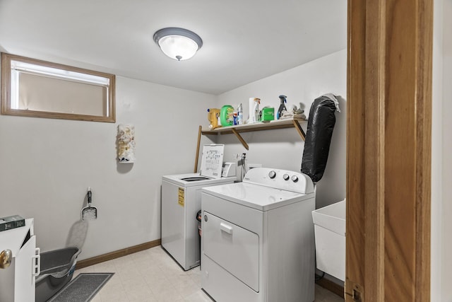 laundry room featuring laundry area, baseboards, and washing machine and clothes dryer