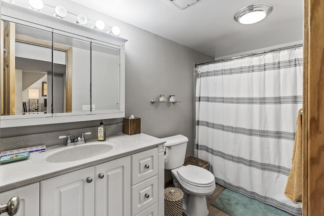 bathroom with visible vents, toilet, vanity, and a shower with curtain