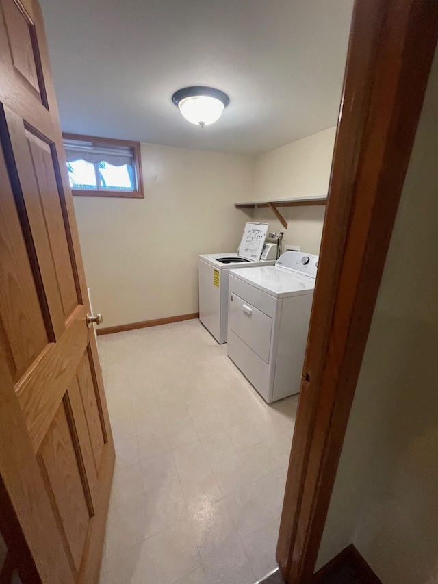 clothes washing area featuring baseboards, light floors, laundry area, and washer and dryer