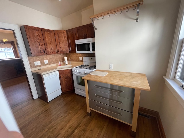 kitchen with white appliances, a sink, wooden counters, dark wood-style floors, and tasteful backsplash