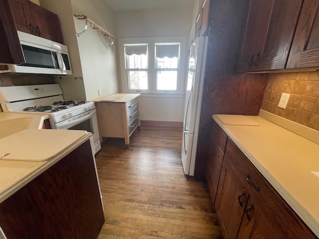 kitchen with white appliances, tasteful backsplash, dark wood-type flooring, light countertops, and dark brown cabinets