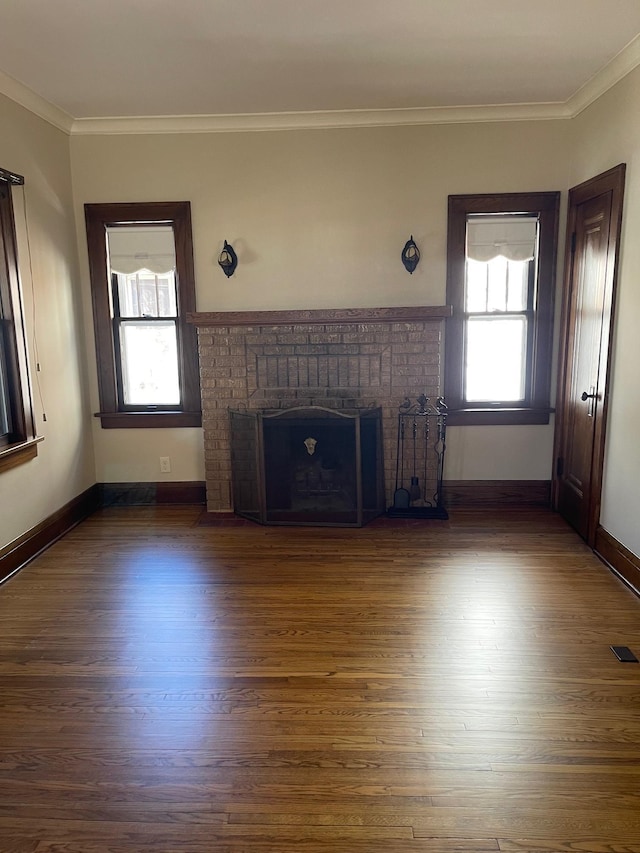 unfurnished living room with dark wood-type flooring, a wealth of natural light, and a fireplace