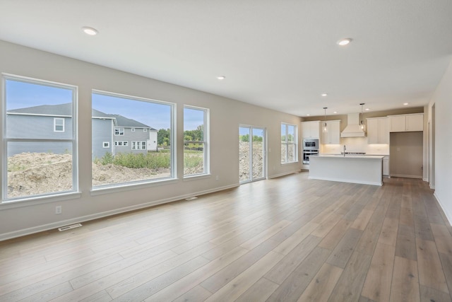 unfurnished living room featuring recessed lighting, visible vents, and light wood-style floors