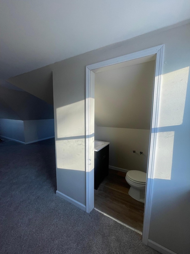 bathroom with toilet, vanity, and baseboards