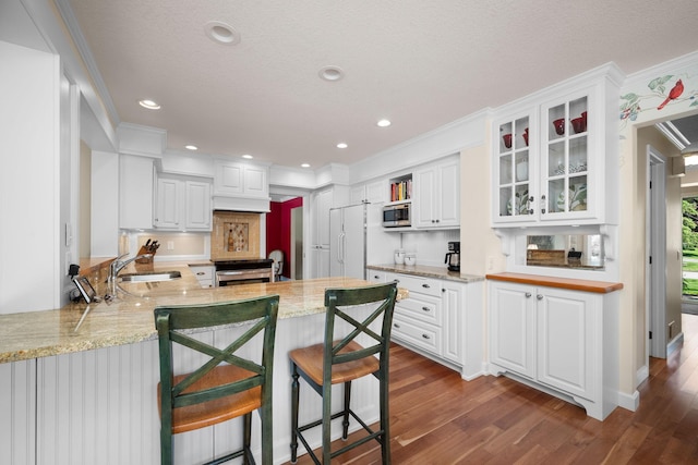 2135 Shadyview Ln N, Plymouth, MN 55447 - kitchen featuring appliances with stainless steel finishes, a peninsula, dark wood-type flooring, white cabinets, and glass insert cabinets