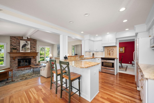 2135 Shadyview Ln N, Plymouth, MN 55447 - kitchen with stainless steel electric range, a peninsula, light wood-style floors, a kitchen breakfast bar, and recessed lighting