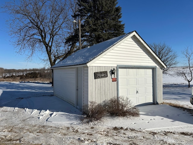 snow covered garage with a garage