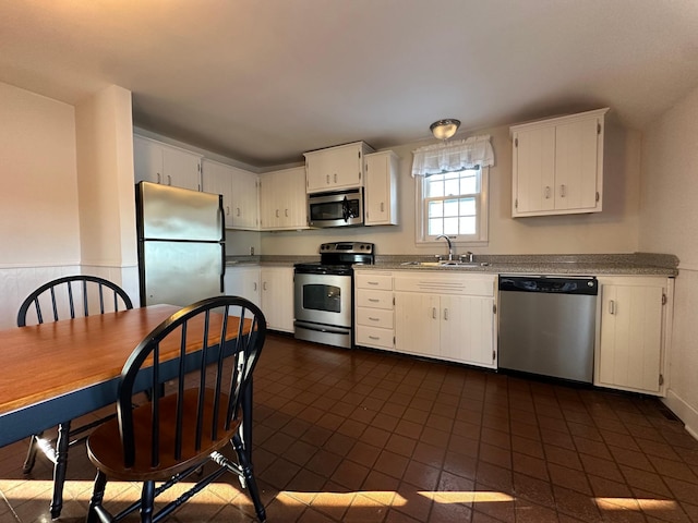 kitchen featuring light countertops, appliances with stainless steel finishes, a sink, and white cabinetry