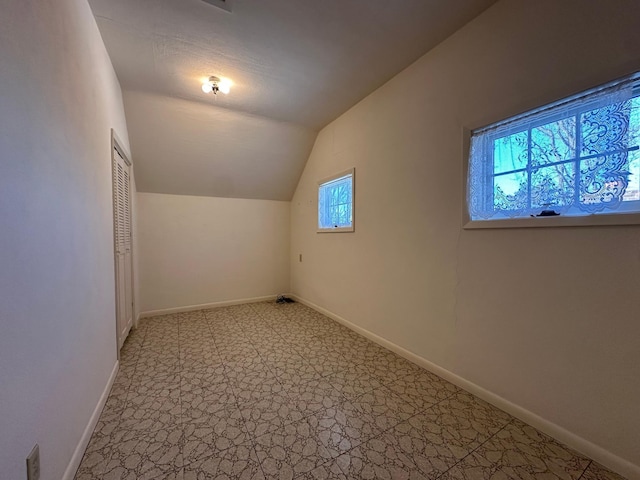 bonus room with vaulted ceiling and baseboards