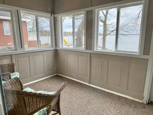 sunroom featuring a water view