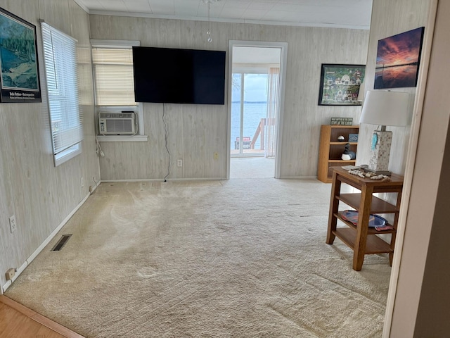 carpeted empty room featuring visible vents, cooling unit, and baseboards