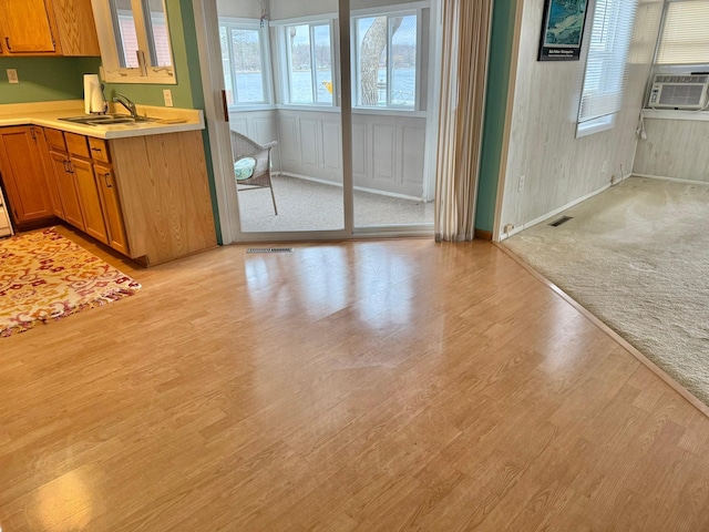 unfurnished dining area featuring a sink, visible vents, baseboards, and light wood-type flooring