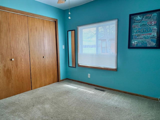 unfurnished bedroom with visible vents, a closet, baseboards, and carpet floors