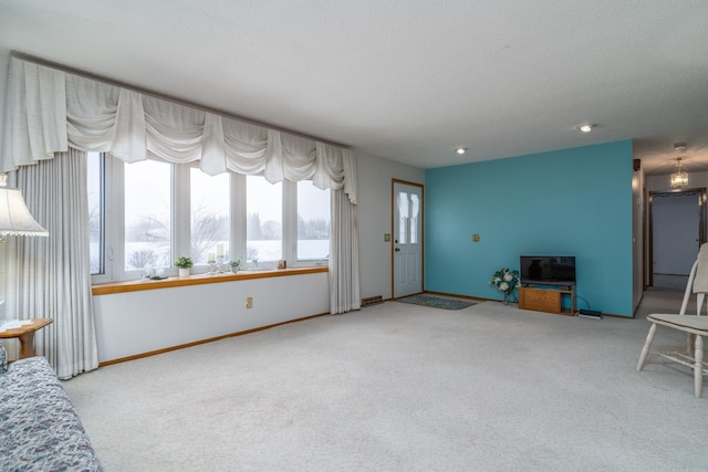 living area with baseboards and light colored carpet