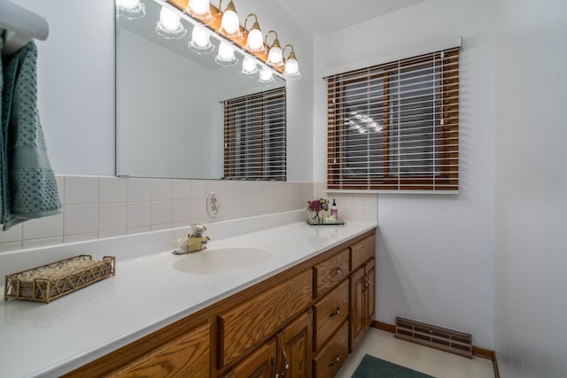 bathroom featuring baseboards, visible vents, vanity, and decorative backsplash