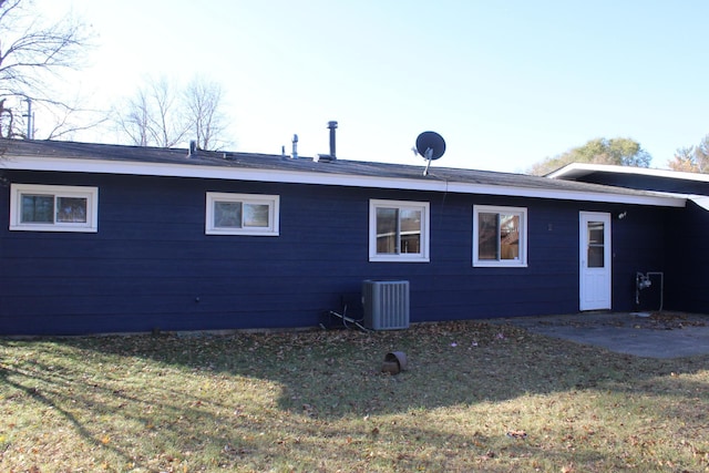 rear view of property with a yard and central air condition unit