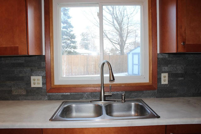 kitchen with light countertops, a sink, and decorative backsplash