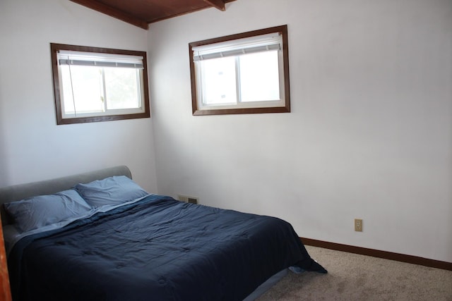 carpeted bedroom with vaulted ceiling, visible vents, and baseboards